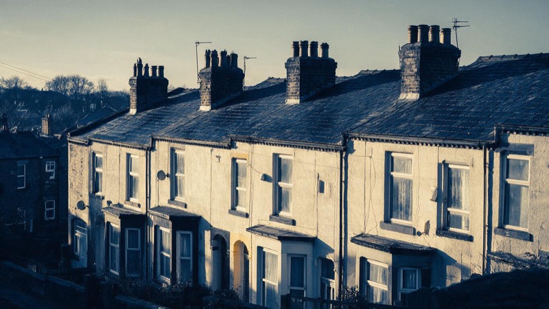 A row of Victorian terraced rental houses in Leeds, slate roofs and chimney pots, photographed on a cold clear winter morning