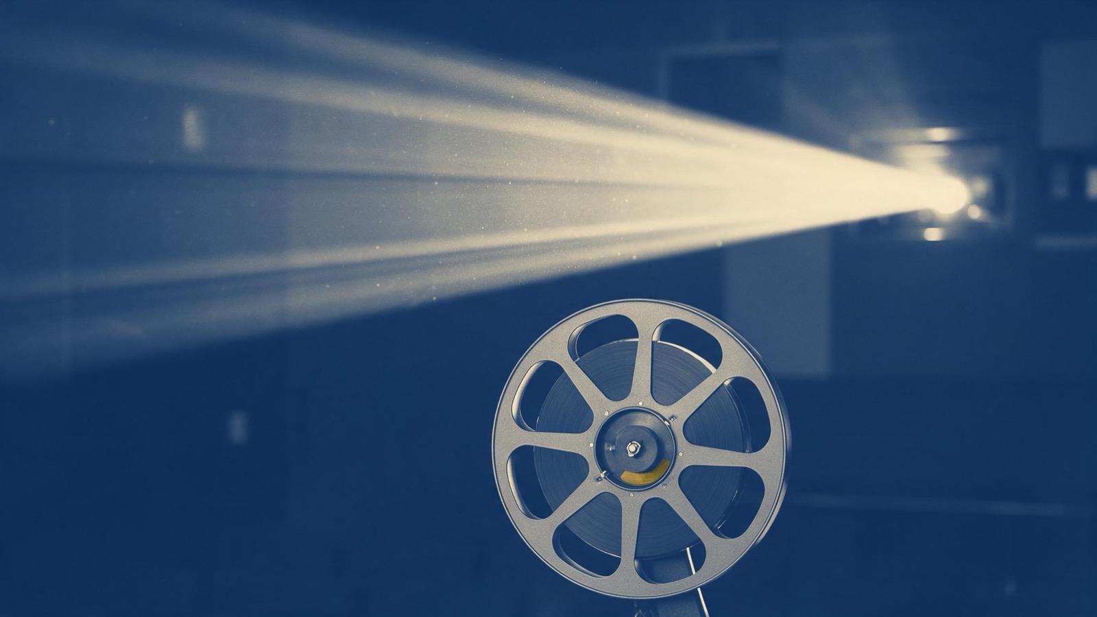 a film reel and projector beam in a dark cinema, dust in the light