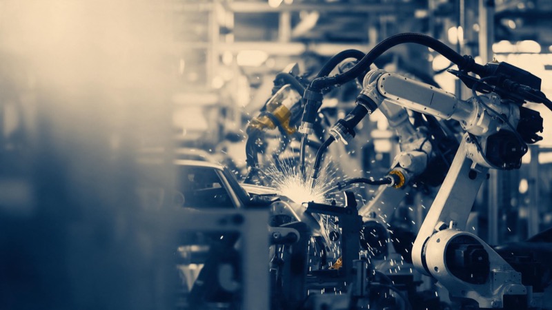 robotic arms on a car assembly line, sparks frozen mid-air